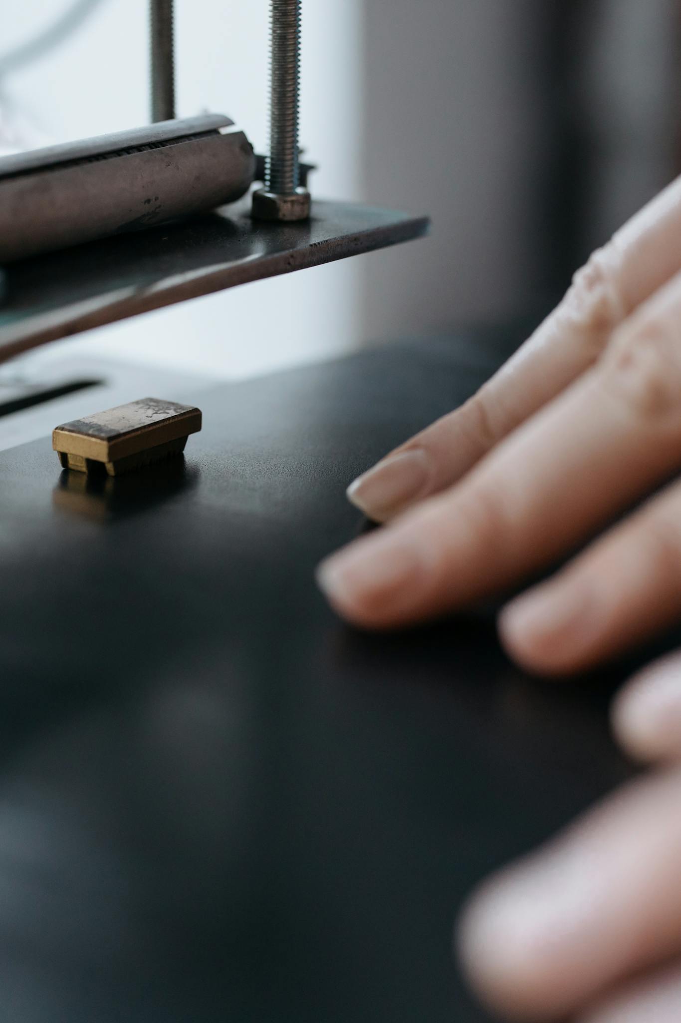 Detailed view of a hand guiding material through an industrial machine.
